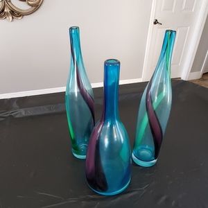 A set of 3 blue glass vases.